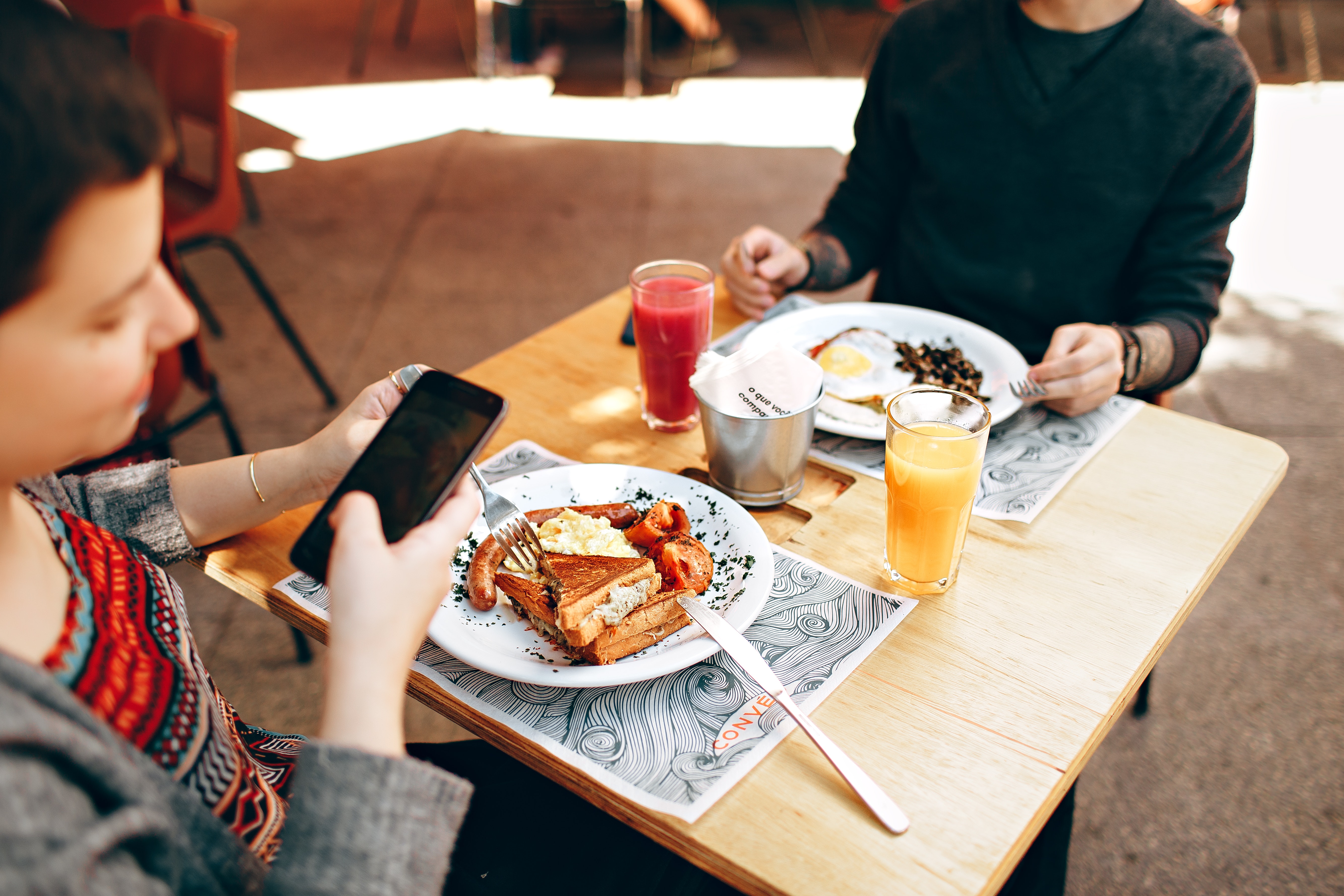 two people at table with phone