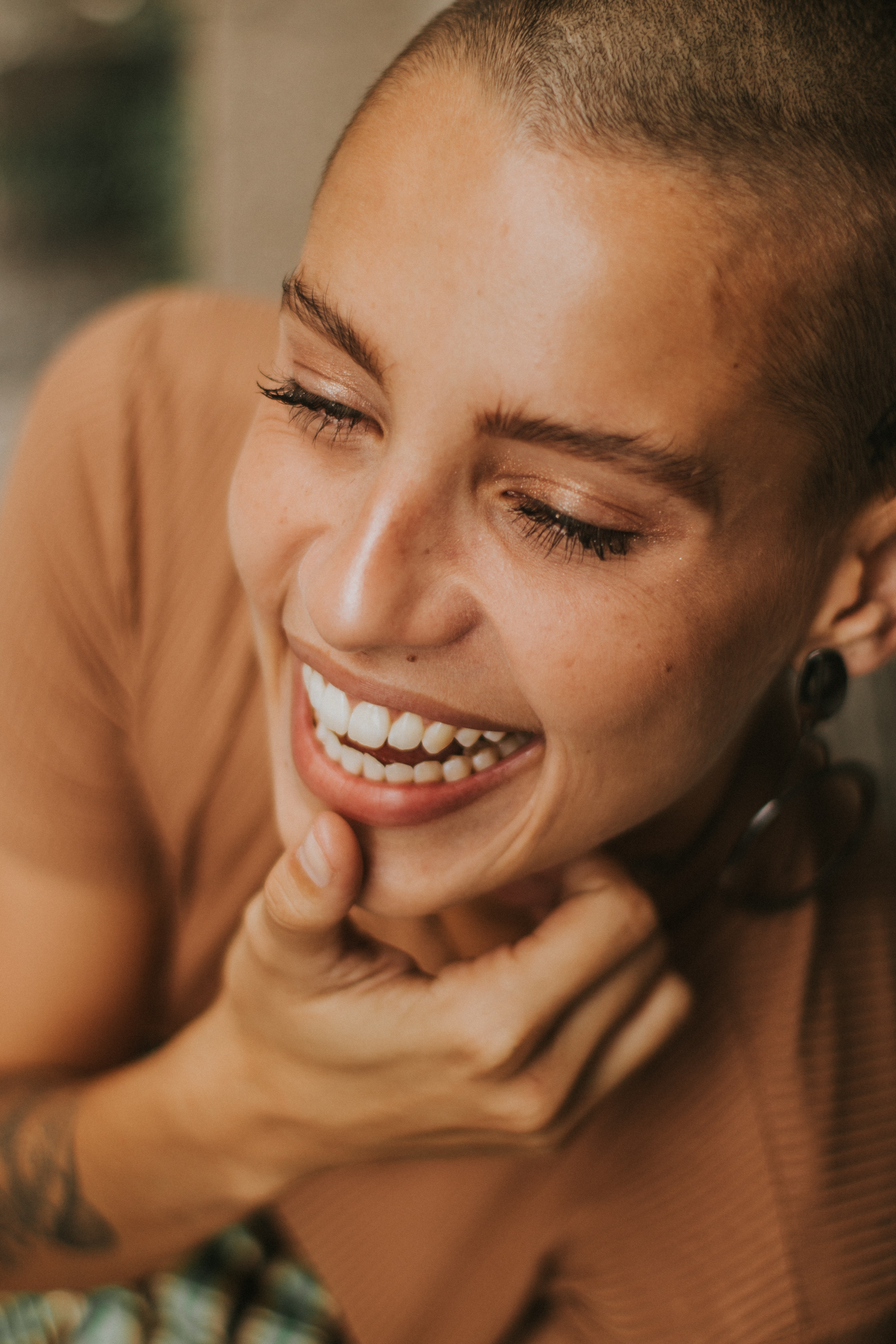 woman smiling looking down her with thumb on her chin